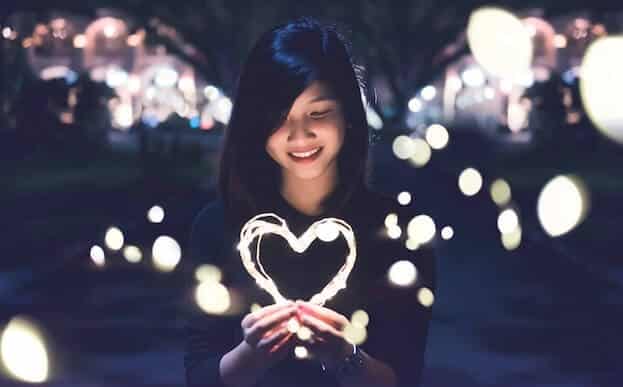 girl holdig the signum of a heart