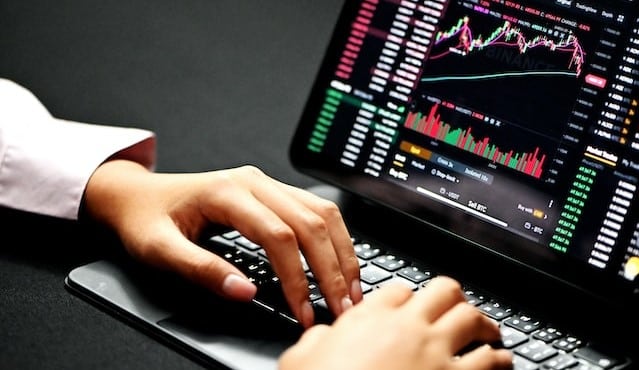 Hands on a laopto showing Finance graphs